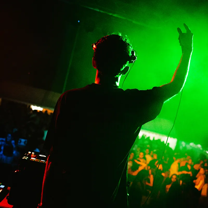 Raude trabajando de DJ mientras la gente le escucha